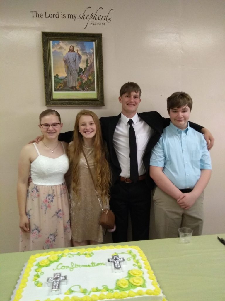 Youth standing in front of a cake on their confirmation day